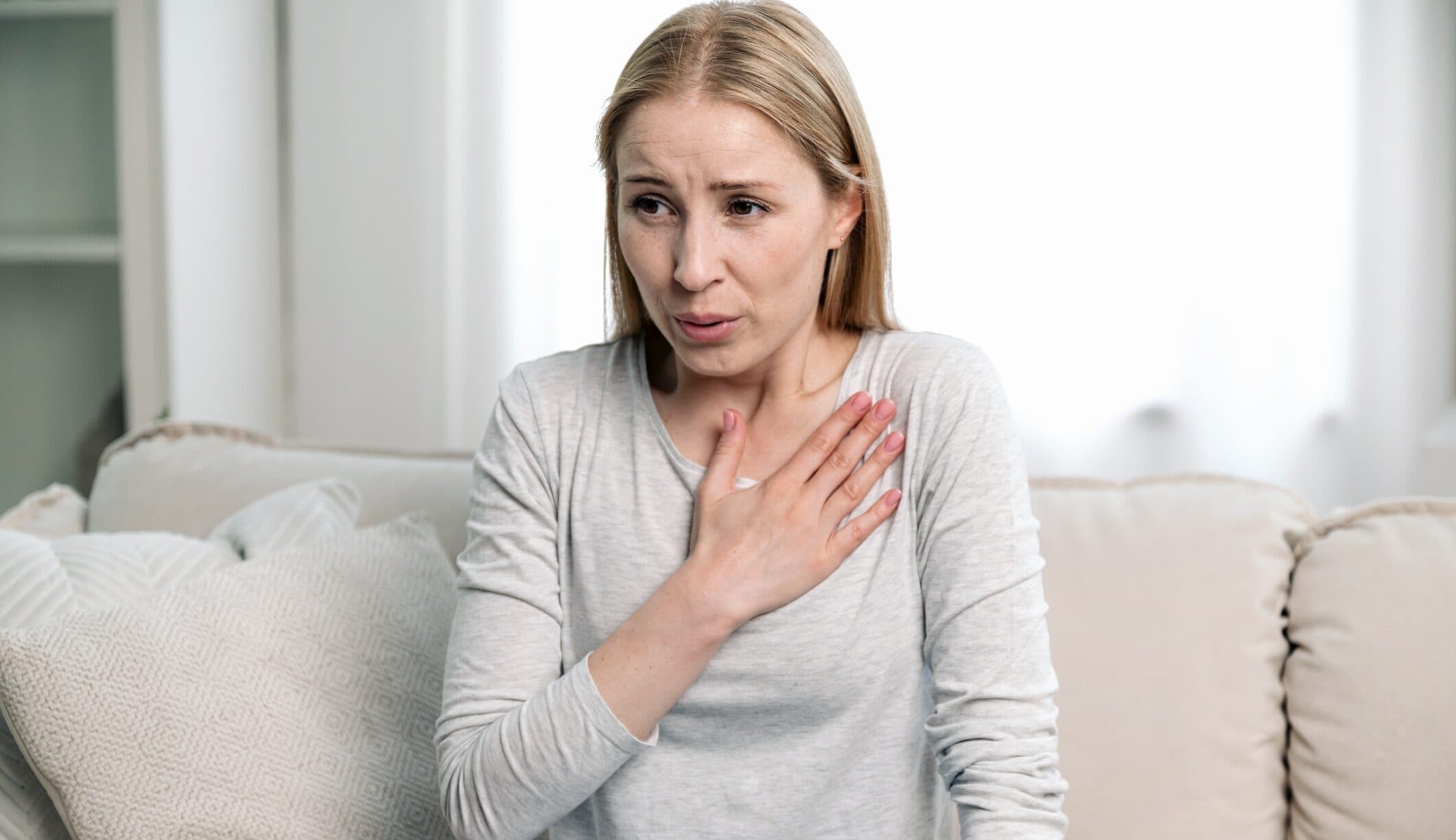 Woman with her hand pressed to her chest